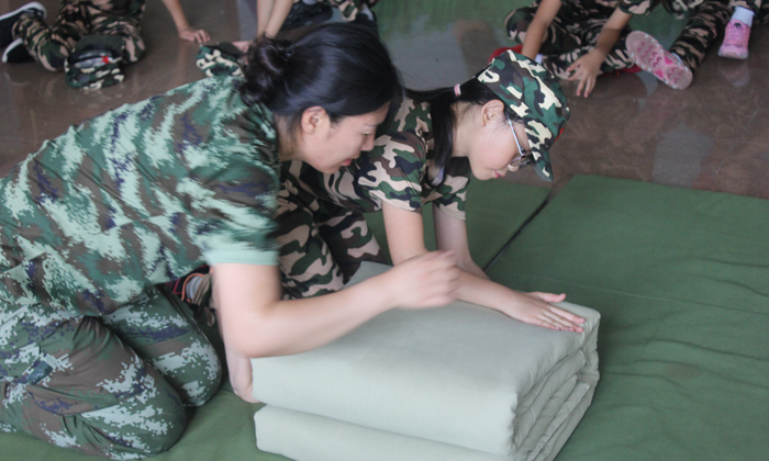 每個學(xué)生整理內(nèi)務(wù)都有老師在旁邊指導(dǎo)