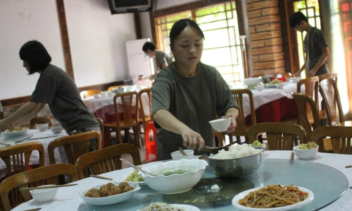 助教在給孩子們盛飯菜