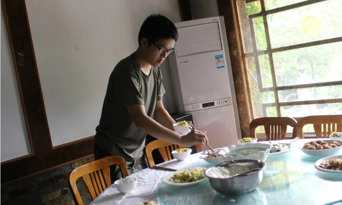 助教在給孩子們盛飯菜